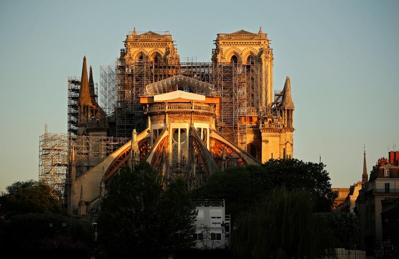 This picture taken on April 14, 2020 shows the Paris' Cathedral Notre Dame at the sunrise on the eve of the first anniversary of the violent fire who destroyed a large part of the monument, on the twenty-nineth day of a lockdown in France to stop the spread of the  COVID-19, (the novel coronavirus). - One year ago, on April 15, 2019, a fire erupted in Notre-Dame Cathedral in Paris, partly destroying the nearly millenium old building and its precious artworks visited by millions of people a year. (Photo by THOMAS COEX / AFP)