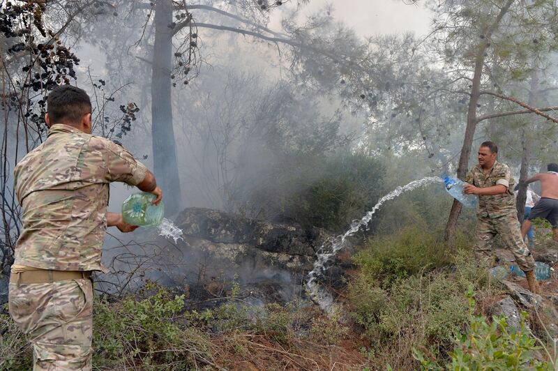 epa07922182 Lebanese army soldiers try to extinguish a fire in Mechref area south Beirut, Lebanon, 15 October 2019. According to reports, 18 Lebanese people were admitted to hospitals for treatment following multiple wildfires that began early on 14 October in Mechref, Dibbiyeh and Al Damour areas at Chouf District in Mount Lebanon. Lebanese Army helicopters and planes provided by Cyprus were fighting the fires on 15 October morning as dozens of Civil Defense teams worked to extinguish blazes that entered residential areas. Five Civil Defense firefighters have sustained injuries during their duty.  EPA/WAEL HAMZEH