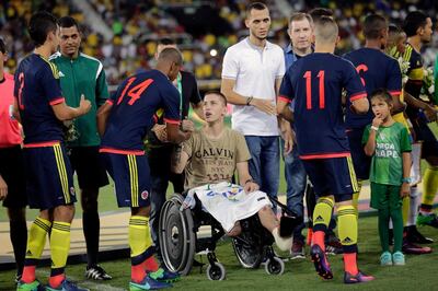 FILE - In this file photo dated Wednesday, Jan. 25, 2017, former Chapecoense goalkeeper Follmann, in wheelchair, greets various Colombia's soccer players prior to a friendly match at the Nilton Santos stadium in Rio de Janeiro, Brazil, in tribute to Chapecoense soccer players who died in a plane crash in Colombia last November. Follmann survived the crash.  Chapecoense player Tulio de Melo said Friday Nov. 17, 2017, that the team have honored the memory of their dead teammates, by avoiding relegation in the Brazilian championship, one year after an air crash killed 19 of its players. (AP Photo/Silvia Izquierdo, FILE)
