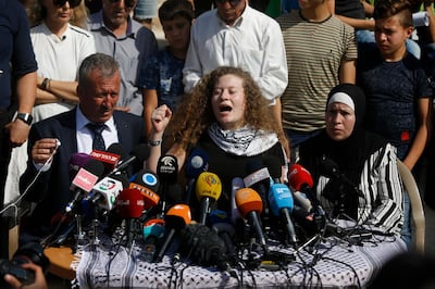 Ahed Tamimi speaks sitting between her father Bassam and mother Nariman during a press conference on the outskirts of the West Bank village of Nabi Saleh near the West Bank city of Ramallah, Sunday, July 29, 2018. Palestinian protest icon Ahed Tamimi and her mother Nariman returned home to a hero's welcome in her West Bank village on Sunday after Israel released the 17-year-old from prison at the end of her eight-month sentence for slapping and kicking Israeli soldiers.(AP Photo/Majdi Mohammed)