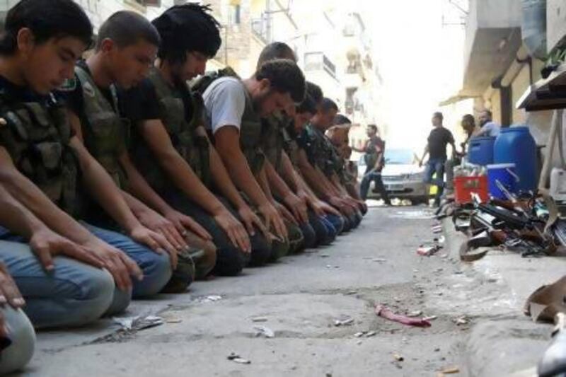 Free Syrian Army fighters pray in a street in Aleppo's Salaheddine neighbourhood.