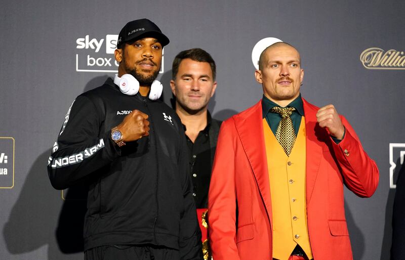 Anthony Joshua, left, and Oleksandr Usyk during a press conference ahead of their world heavyweight title fight at Tottenham Hotspur Stadium in London on Saturday, September 25. Matchroom CEO Eddie Hearn stands between the two fighters. PA