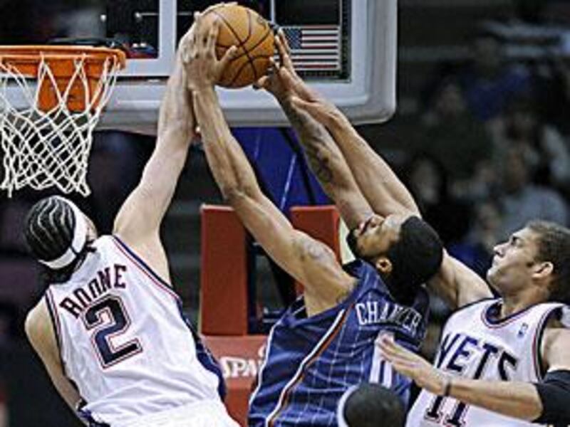 New Jersey Nets' Josh Boone blocks a shot by Charlotte Bobcats' Tyson Chandler with help from Brook Lopez.