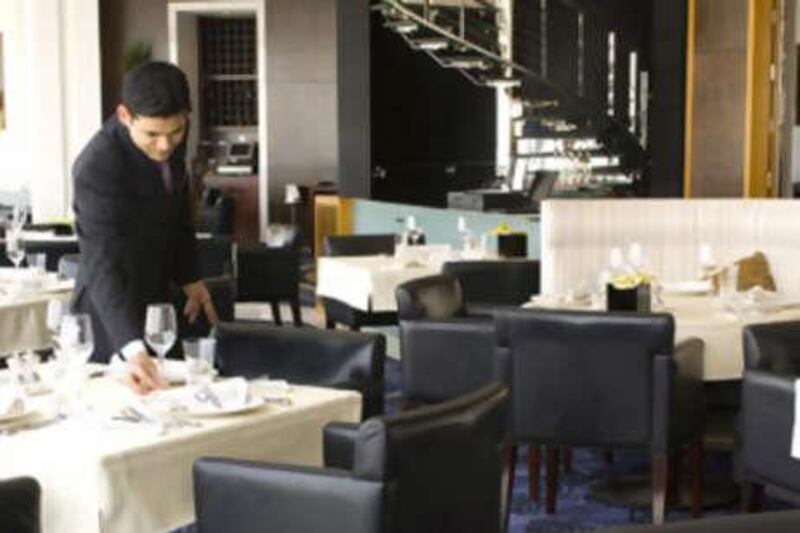 A waiter sets a table at the Vu restaurant in the Emirates Tower Hotel in Dubai.