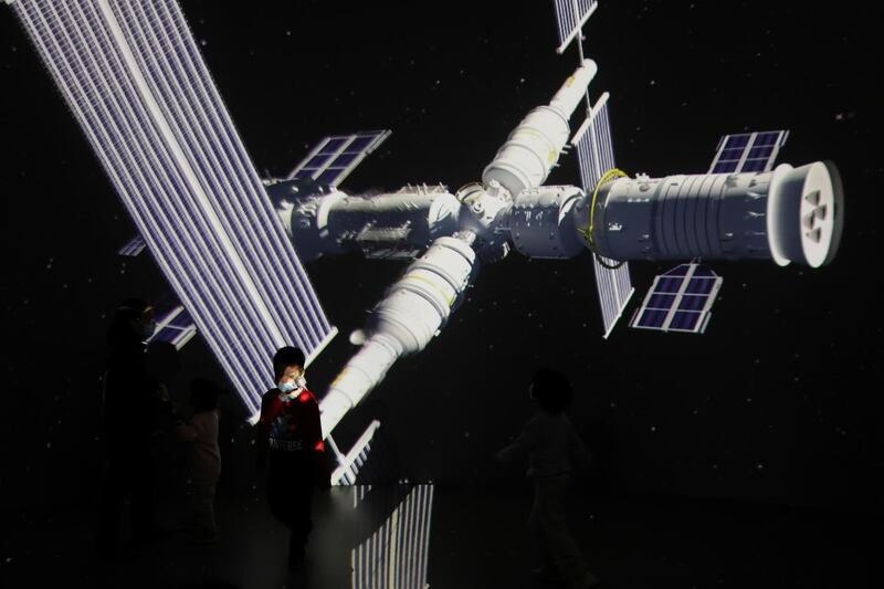 A child stands near a giant screen showing the images of the Tianhe space station at an exhibition featuring the development of China's space exploration on the country's Space Day at China Science and Technology Museum in Beijing. Reuters