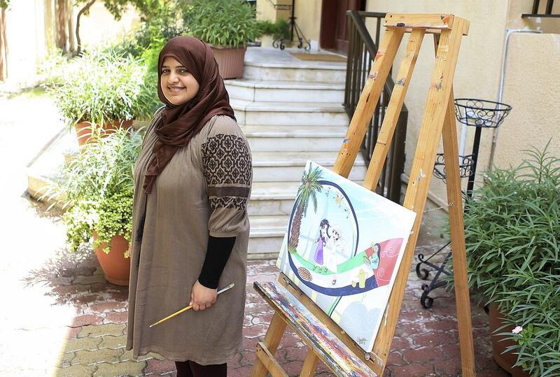 Emirati artist Sheikha Al Shamsi, who was born deaf, with one of her works outside her home in Al Rashidiya, Dubai. She has ambitions to become a professional. Sarah Dea / The National