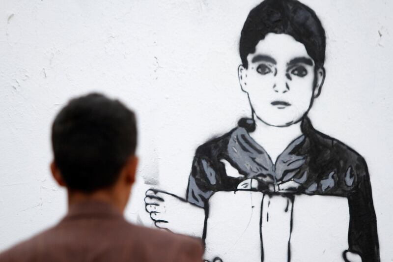 A passer-by looks at Haifa Subay's mural 'Just a leg' in Sanaa. Mohamed Al Sayaghi / reuters