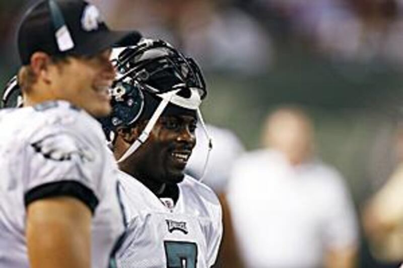 Michael Vick laughs on the sidelines after rushing for a touchdown in the second quarter during a pre-season game against the New York Jets on September 3.