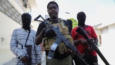 Former police officer Jimmy 'Barbecue' Cherizier, leader of the G9 criminal alliance, is flanked by gang members after a press conference in Port-au-Prince, Haiti. Reuters