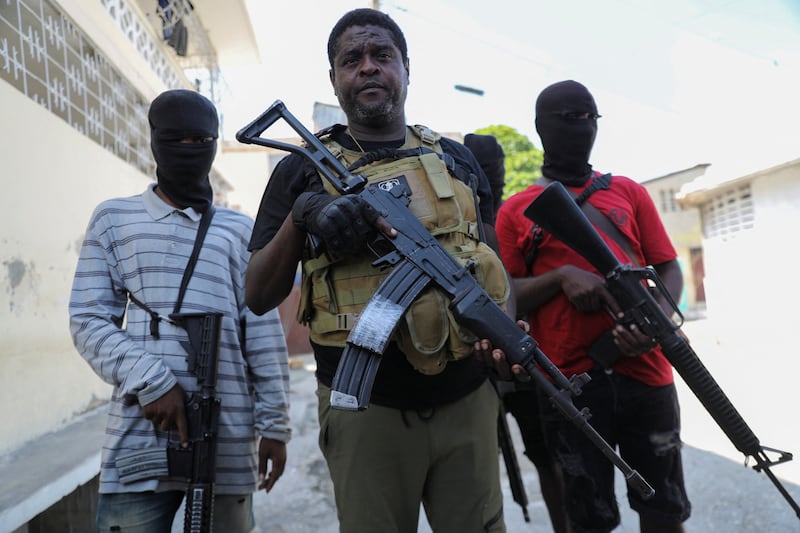 Former police officer Jimmy 'Barbecue' Cherizier, leader of the G9 criminal alliance, is flanked by gang members after a press conference in Port-au-Prince, Haiti. Reuters