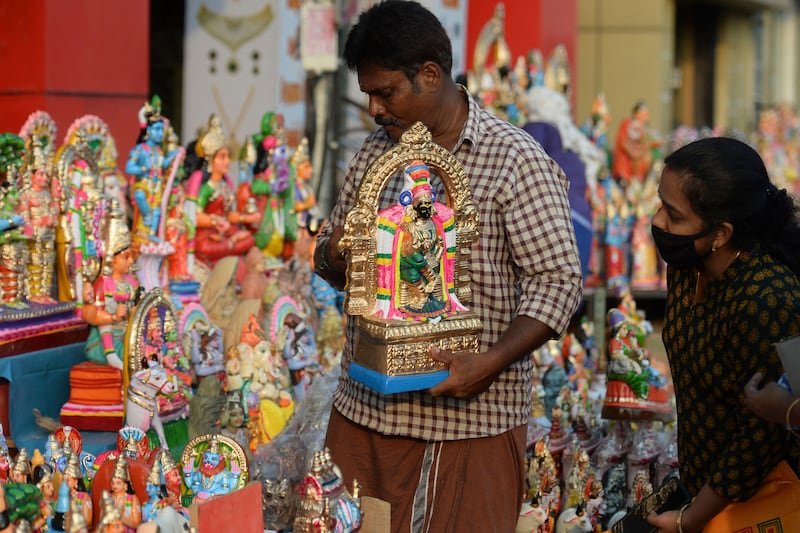 A vendor arranges idols representing deities and characters from Hindu mythology at a stall, during Navratri in Chennai. AFP