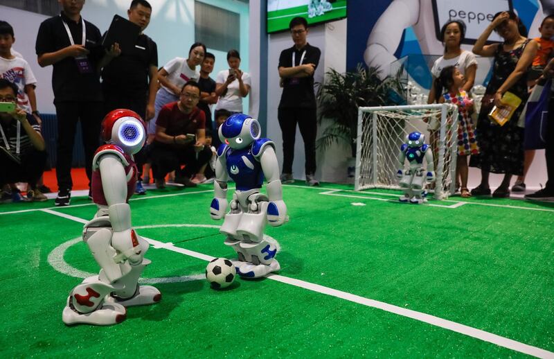 Visitors watch robots playing football during the 2018 World Robot conference. EPA