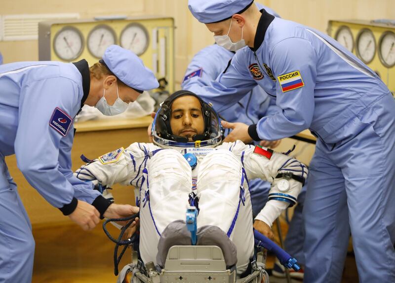 Russian Space Agency experts help Hazza Al Mansouri, member of the main crew of the expedition to the International Space Station, to sit during an inspection of his space suit prior the launch of Soyuz MS-15 space ship on Wednesday. Dmitri Lovetsky / AP