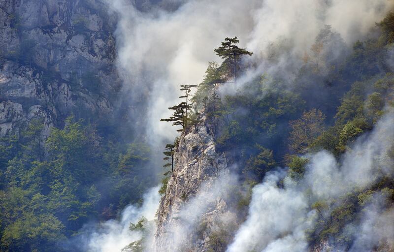 Smoke bellows from wildfire in the mountains near the Piva lake,  northwest Montenegro.