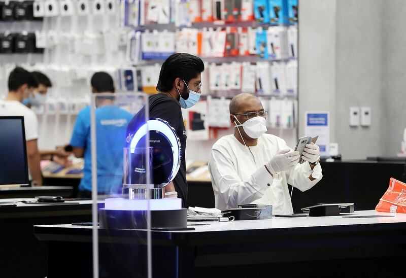 DUBAI, UNITED ARAB EMIRATES , April 29 – 2020 :- Shoppers wearing protective face mask to prevent the spread of the coronavirus at the Samsung store at Mall of the Emirates in Dubai. Authorities ease the restriction for the residents in Dubai. At present mall opening timing is 12:00 pm to 10:00 pm. Carrefour timing is 9:00 am to 10:00 pm. (Pawan Singh / The National) For News/Standalone/Online. Story by Patrick