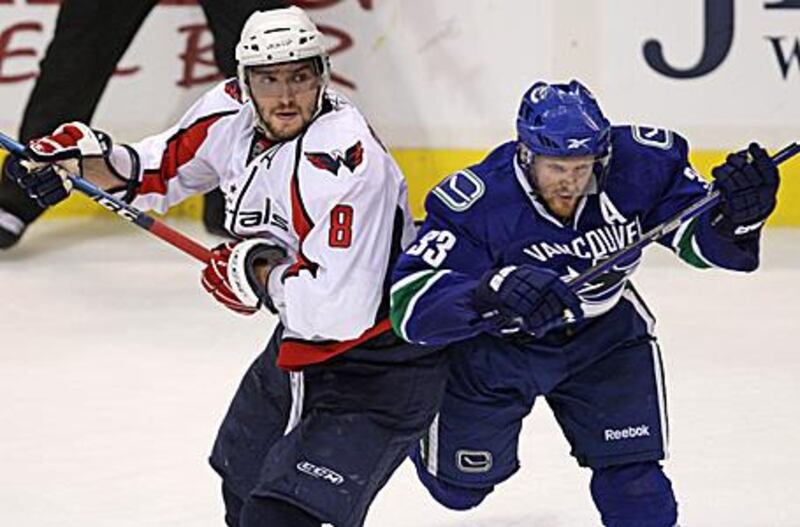 Alexander Ovechkin, left, is checked by the Canucks' Henrik Sedin. The Capitals' player failed to score as the Canucks won 3-2.