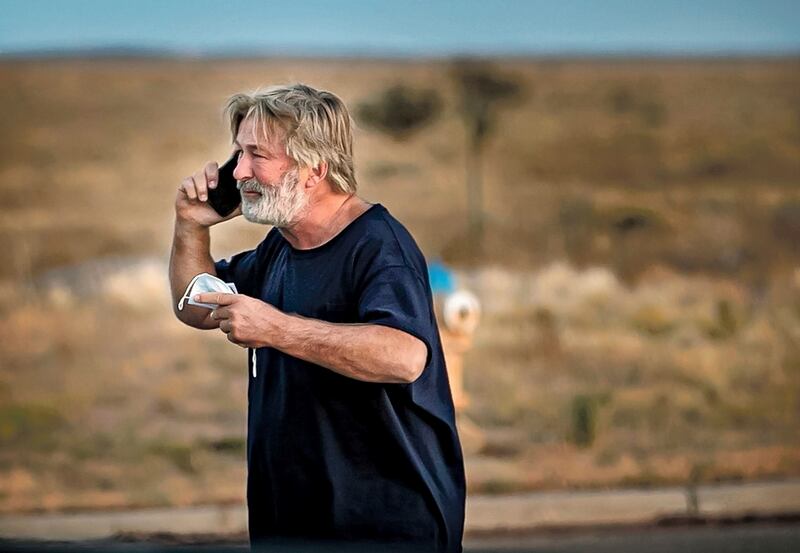 Alec Baldwin speaks on the phone in the parking lot outside the Santa Fe County Sheriff's Office in Santa Fe, N. M. , after he was questioned about a shooting on the set of the film "Rust" on the outskirts of Santa Fe, Thursday, Oct.  21, 2021.  Baldwin fired a prop gun on the set, killing cinematographer Halyna Hutchins and wounding director Joel Souza, officials said.  (Jim Weber / Santa Fe New Mexican via AP)