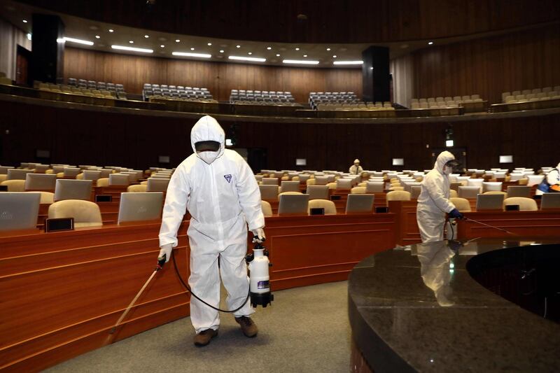 Workers from the South Korea Pest Control Association spray disinfectant as part of preventative measures against the spread of coronavirus at the National Assembly. AFP