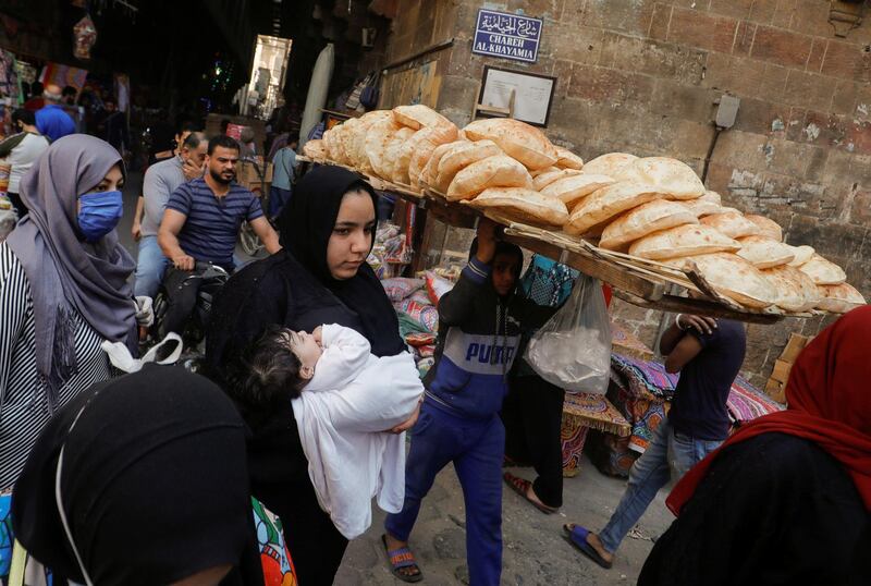 A man carries bread on wooden racks to be sold to customers at Al Khayamia street. Reuters