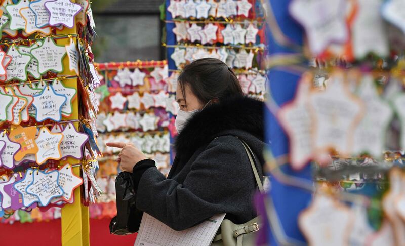 A Buddhist devotee attaches name cards with wishes during celebrations for the New Year at the Jogye temple, in Seoul. AFP