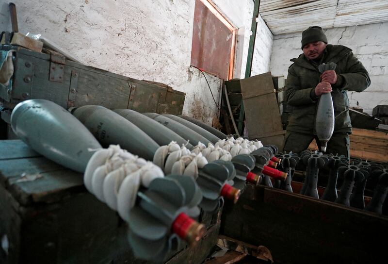 A member of pro-Russian unit in uniform without insignia handles a mortar round at a weapons depot near Marinka, in the Donetsk region of Ukraine. Reuters