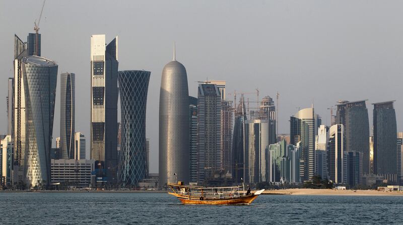 A traditional dhow floats in the Corniche Bay of Doha, Qatar, in front of the city's financial district in the background. Shares in the country's banks slumped on Sunday as the country's economic isolation continues. Saurabh Das / AP Photo