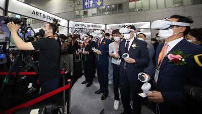 Visitors wearing virtual reality goggles and handling controllers experience a VR presentation at a metaverse conference in South Korea. EPA