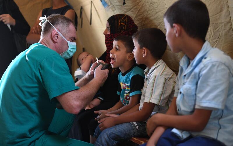 A Russian medic checks a Syrian child in a tent set up at the Abu Duhur crossing. AFP