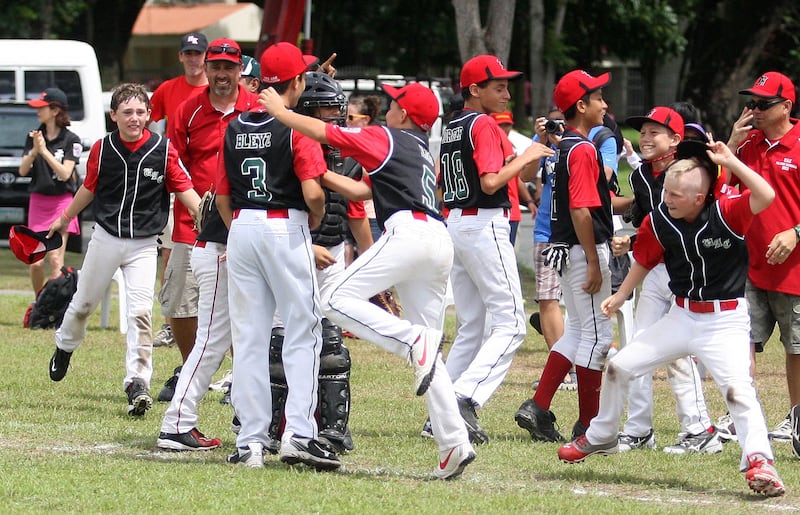 Clarke Philippines, July 5 2013, Asian Pacific Middle East Playoffs, Paul Radley Story- UAE All-Stars celebrate their victory over, downing the Powerhouse team of Guam, temmates swarm closer Lukas Bley as he walked off the mound.  Team UAE defeated Guam 9-8 for the UAE's first win. Mike Young for The National 