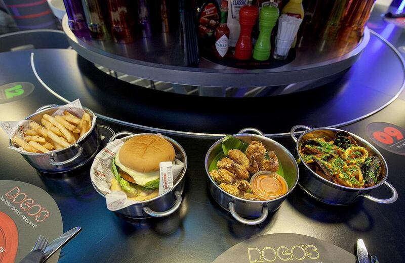  The wide range of dishes at ROGO's include, from left, the Tornado Burger, fried shrimp and seafood linguine. Mona Al Marzooqi / The National