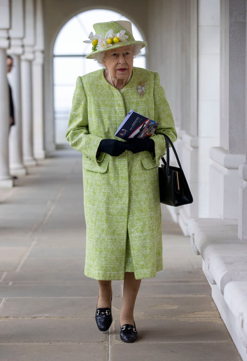 Queen Elizabeth II, wearing light green, during a visit to The Royal Australian Air Force Memorial on March 31, 2021, near Egham, England. Getty Images