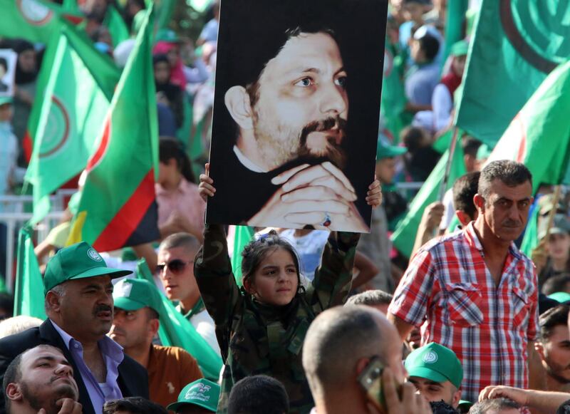 Amal movement supporters hold up pictures of Imam Musa al-Sadr and wave the Shiite movement's green flags during a ceremony held in the town on Baalbeck, east of the capital Beirut on August 31, 2018, to commemorate the disappearance of the former head of the Higher Shiite Council in Lebanon, Imam al-Sadr. - Sadr, the founder of the Amal movement which played a major role in Lebanon's civil war between 1975 and 1990, vanished while on a trip to Libya in 1978. (Photo by STR / AFP)