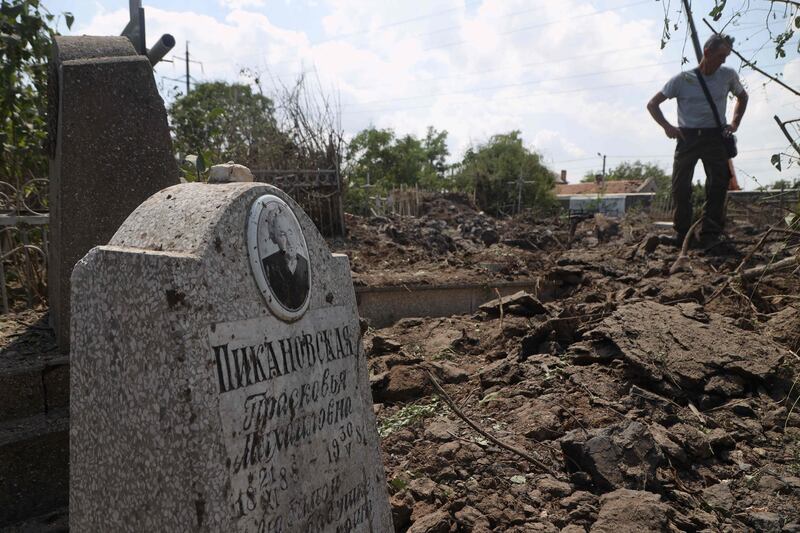 A local resident stands next to a crater in a cemetery in Odesa, hit during a missile strike on July 19. AFP