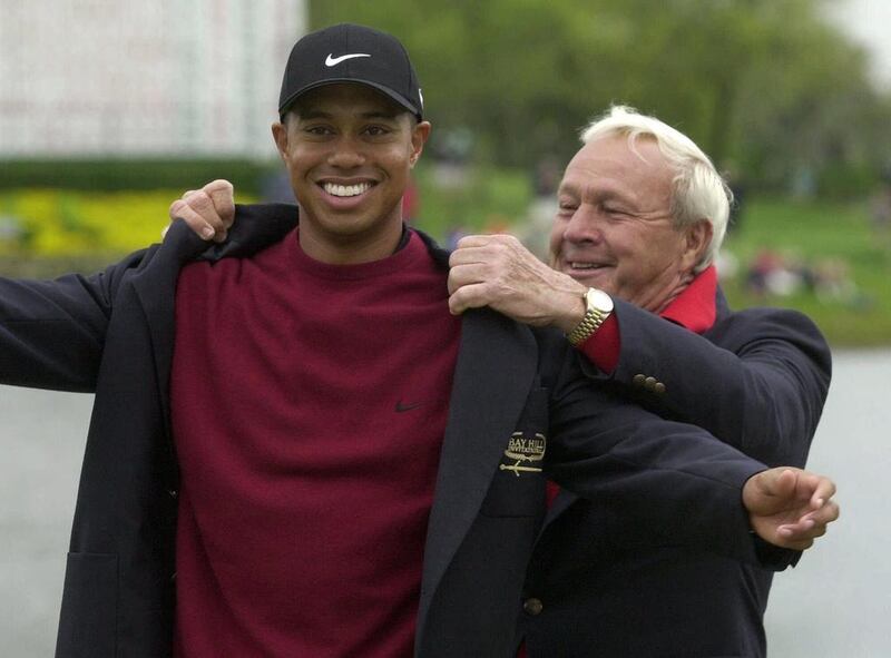 This March 18, 2001, file photo shows Tiger Woods, left, being helped into his jacket after winning the Bay Hill Invitational by tournament host Arnold Palmer in Orlando, Florida. AP Photo