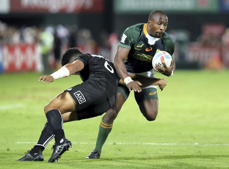 Dubai, United Arab Emirates - December 07, 2019: Siviwe Soyizwapi of South Africa is tackled by Ngarohi McGarvey-Black of New Zealand during the game between New Zealand and South Africa in the mens final at the HSBC rugby sevens series 2020. Saturday, December 7th, 2019. The Sevens, Dubai. Chris Whiteoak / The National