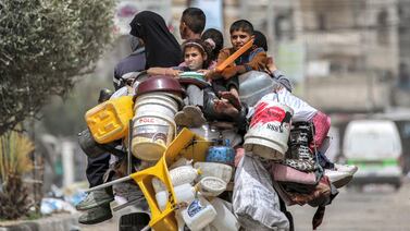 A man, woman, and children ride in the back of a tricycle loaded with belongings and other items as they flee bound for Khan Yunis, in Rafah in the southern Gaza Strip on May 11, 2024 amid the ongoing conflict in the Palestinian territory between Israel and Hamas.  (Photo by AFP)