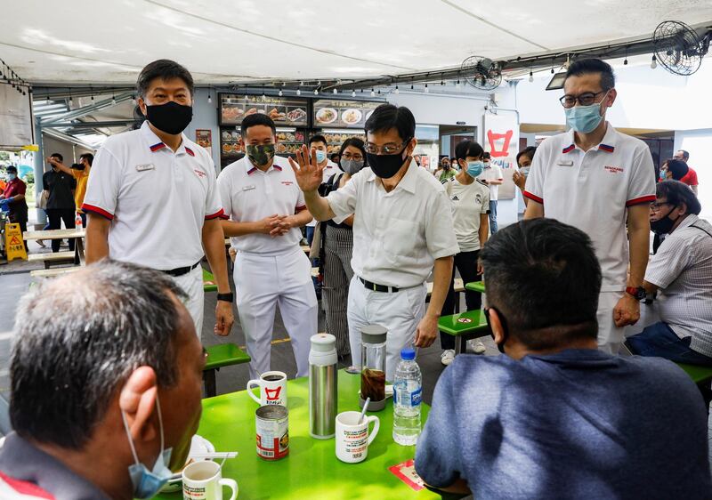 Ng Chee Meng, Heng Swee Keat and Raymond Lye of the PAP speak to residents during a walkabout ahead of the general election in Singapore on Sunday. Reuters