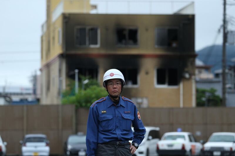 A firefighter stands near the scene where at least two dozen people died in a fire at an animation company building. AFP