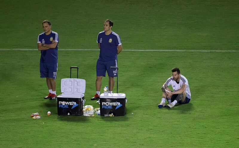 Messi enjoys a sit on the grass during the session. EPA