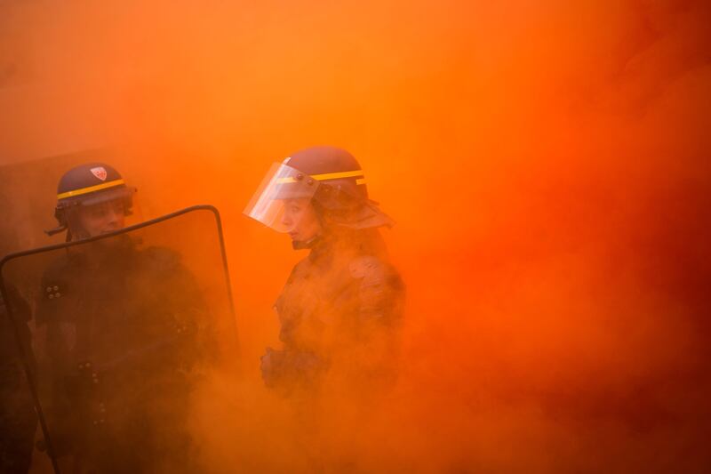 A policewoman stands surrounded by smoke during a demonstration of metalworkers in the streets of Paris.
Several thousand workers have taken part in a protest organised by French union CGT for the metallurgy industry to demand a national collective "high level" agreement  for the branch in France. Martin Bureau / AFP Photo.