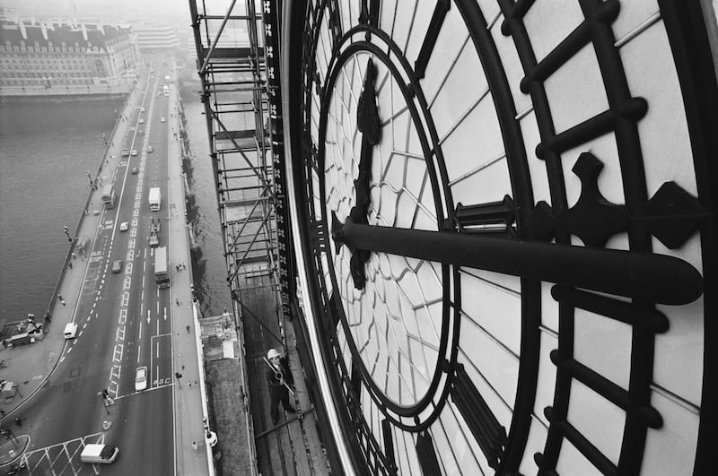 A close up view of the clock face of Big Ben, with Westminster Bridge over the River Thames to the left, in 1985. Getty Images