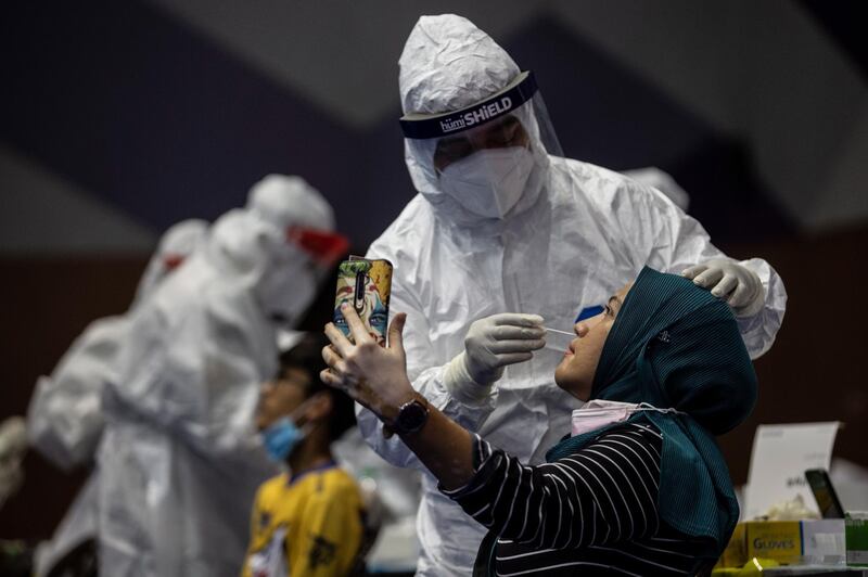 A woman takes a photo as she undergoes a swab test for Covid-19 in Kuala Lumpur, Malaysia. The Malaysian Health Ministry announced the country is still within the 5,000 mark of new positive Covid-19 cases.  EPA