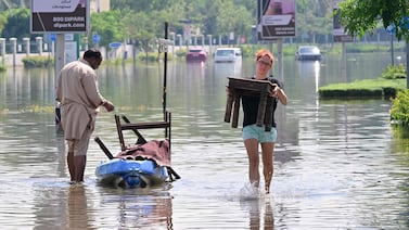 UAE residents unload salvaged belongings from a canoe following the heavy rain in Dubai. AFP