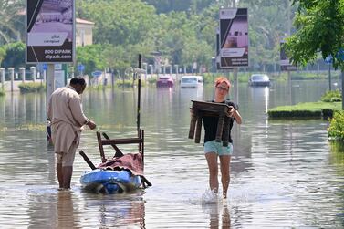 UAE residents unload salvaged belongings from a canoe following the heavy rain in Dubai. AFP