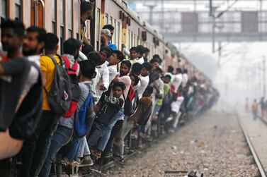 Commuters travel in an overcrowded train near a railway station at Loni town in India's state of Uttar Pradesh on April 24, 2023.  - India is set to overtake China as the world's most populous country by the end of June, UN estimates showed on April 19, posing huge challenges to a nation with creaking infrastructure and insufficient jobs for millions of young people.  (Photo by Arun SANKAR  /  AFP)