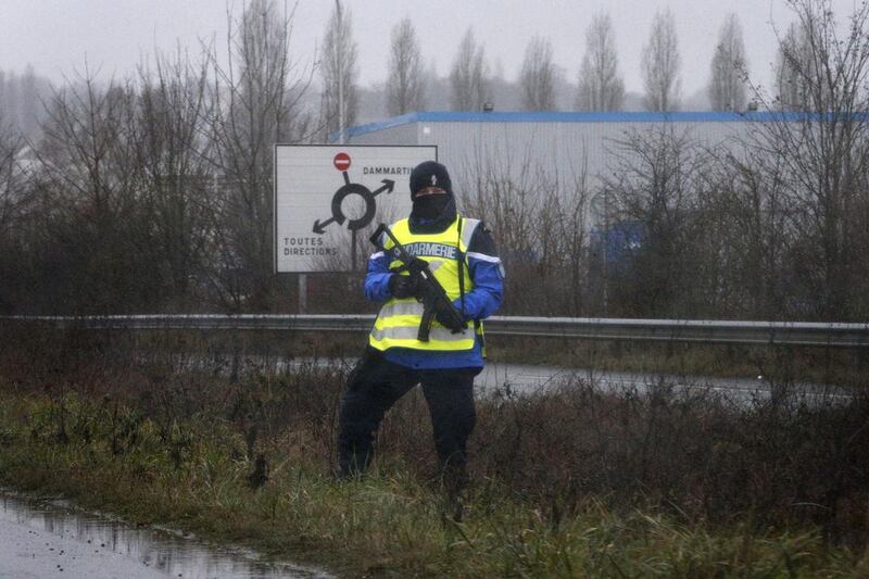 A police officer stands along a road near the industrial area. Yoan Valat / EPA