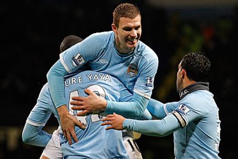 Edin Dzeko, centre, is congratulated by Yaya Toure, left, and Carlos Tevez after providing Yaya with the assist for Manchester City's third goal against Wolves.