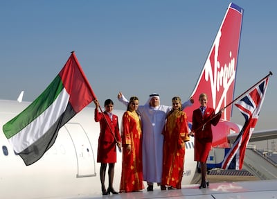 Sir Richard Branson stands with models on a Virgin Atlantic plane wing after the airline's inaugural flight to Dubai in March 2006. Getty Images