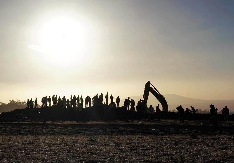 Rescue and recovery personnel use an earth mover to recover debris from a crater where Ethiopian Airlines Flight 302 crashed. Getty Images