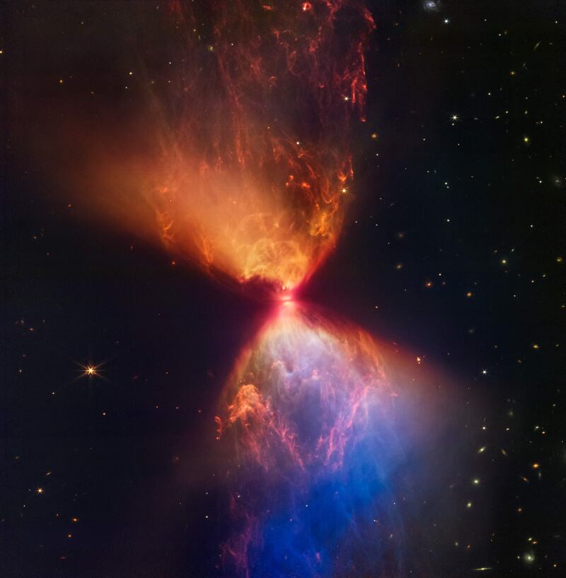 An undated image from Nasa's James Webb Space Telescope near-infrared camera shows the Protostar within the dark cloud L1527 with ejections from the star above and below appearing orange and blue in infrared view. Photo: Nasa